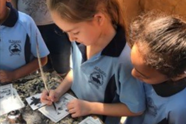 students writing on paper with quill