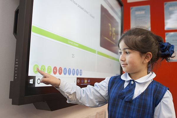 student playing with digital TV monitor at school