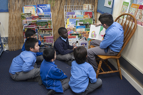 students in a circle reading a book